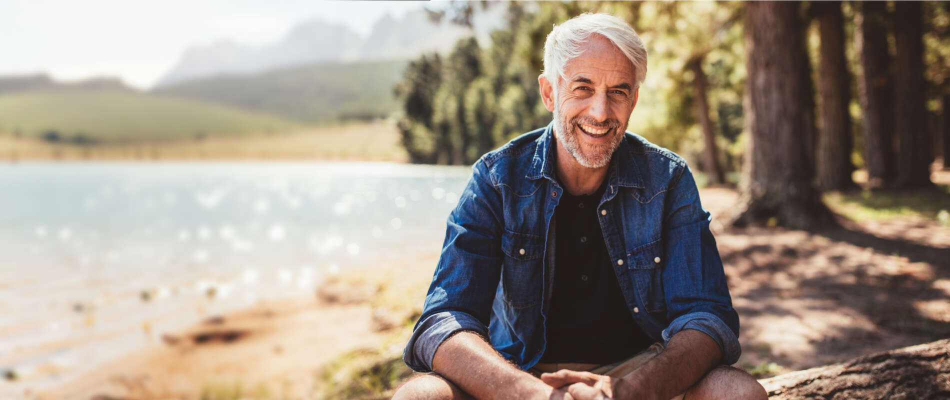 Happy and healthy senior man smiling while enjoying an active lifestyle in nature and outdoor camping