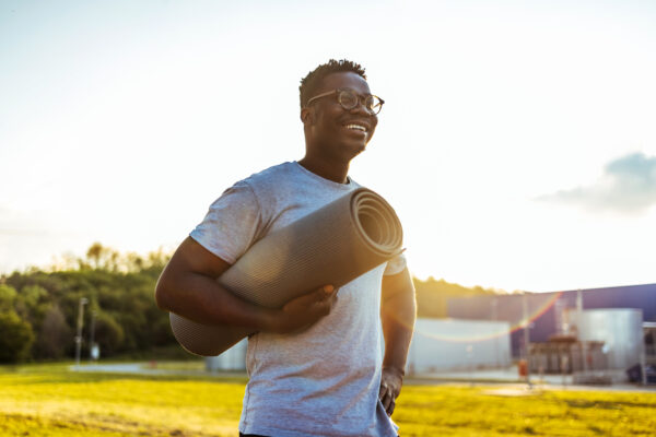 Happy young smiling man standing alone before a yoga session
